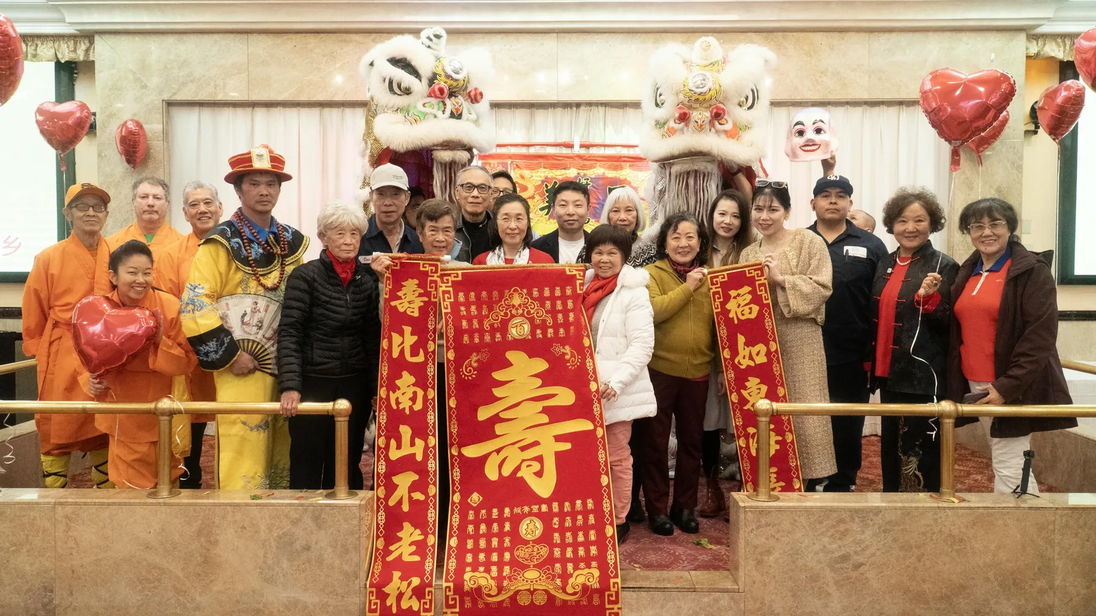 Residents and guests pose with lion dance performers and festive blessing scrolls