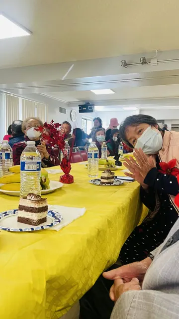 Residents seated at long tables set with cake and fruit