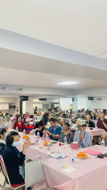Wide view of residents gathered at tables for the birthday party