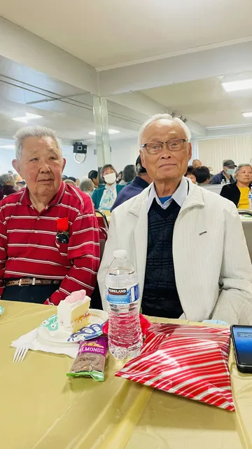 Two residents posing together at the birthday party table