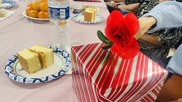 Cake, fruit, and a red flower decoration on the party table