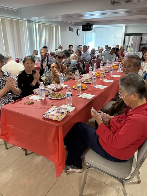 Residents gathered around long tables with refreshments at the June birthday party