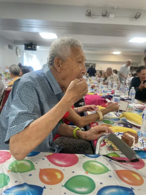A resident enjoying cake at the birthday party