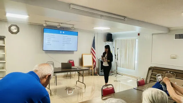 The presenter speaks in front of the projection screen about fraud prevention