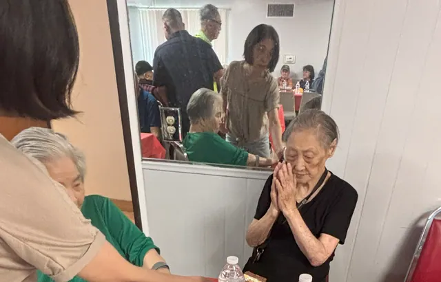 A staff member chatting warmly with residents at the birthday party