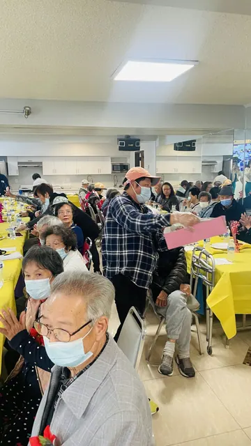Staff handing out papers to residents at the birthday party