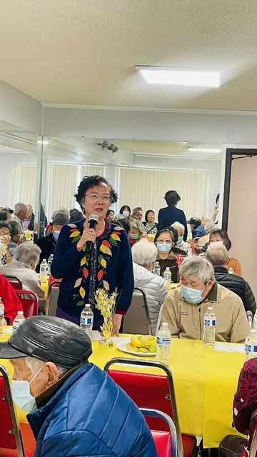 A resident speaking into a microphone at the party