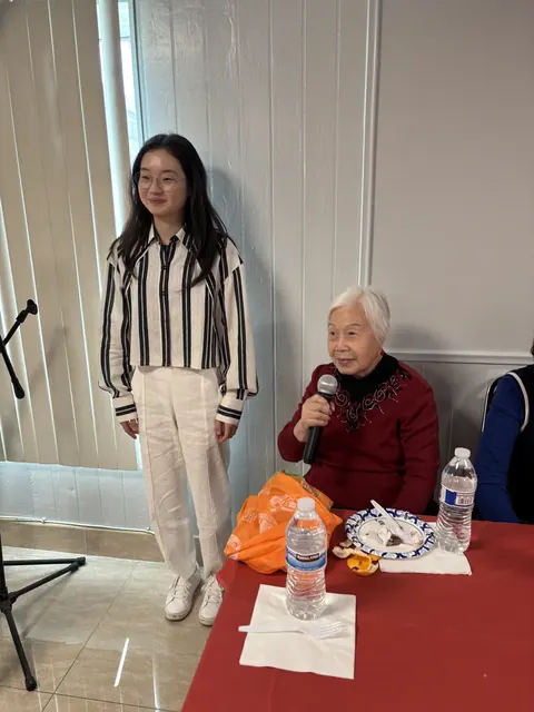 A resident speaking into a microphone at the birthday party