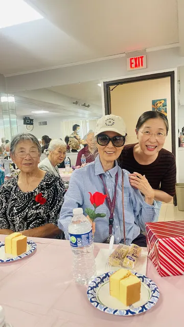 Residents posing together at the birthday party with cake on the table