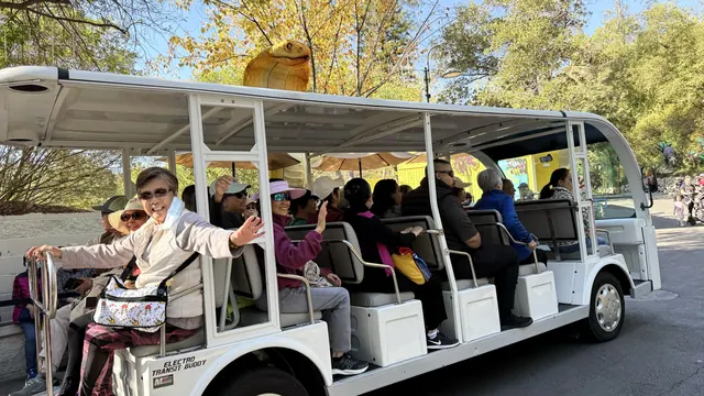 Residents waving from the zoo shuttle tram