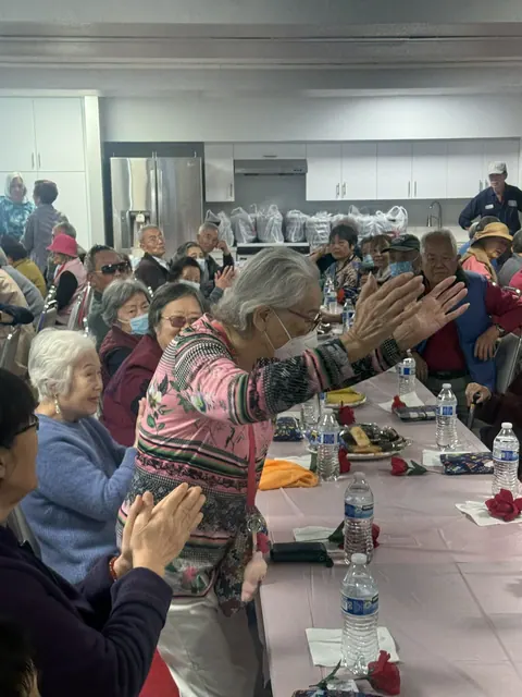 Residents standing and cheering during the lively birthday celebration