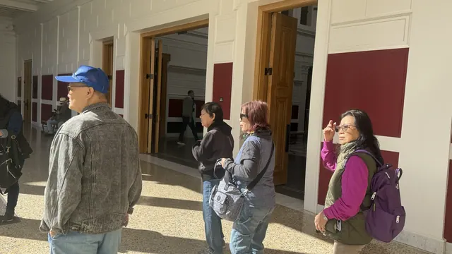 Residents walking through an interior gallery hallway of the museum