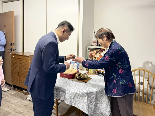A resident shares Mid-Autumn treats with a guest