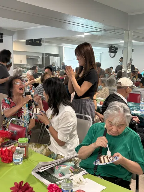 Residents enjoying cake during the lively birthday celebration