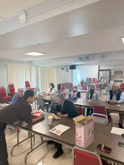 Staff member chatting with residents seated in the activity room