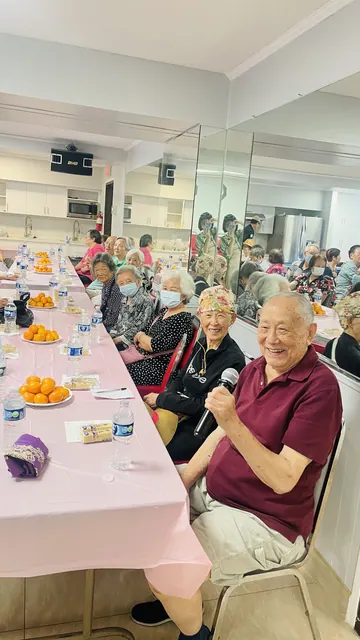 A resident with a microphone laughing with the group