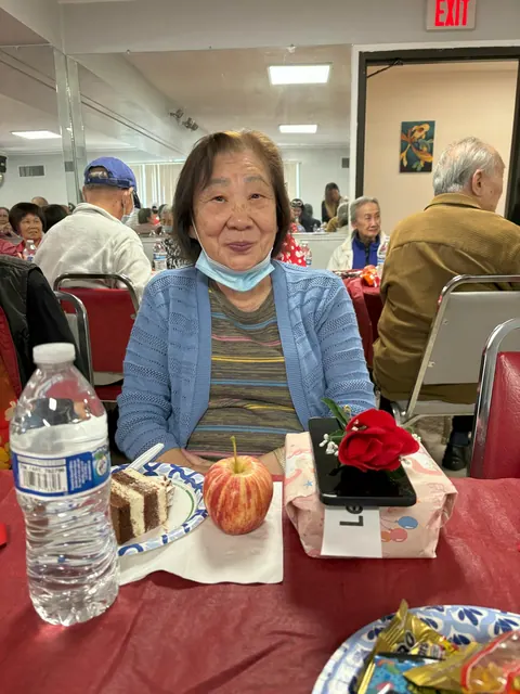 A resident at the table with birthday cake and gifts