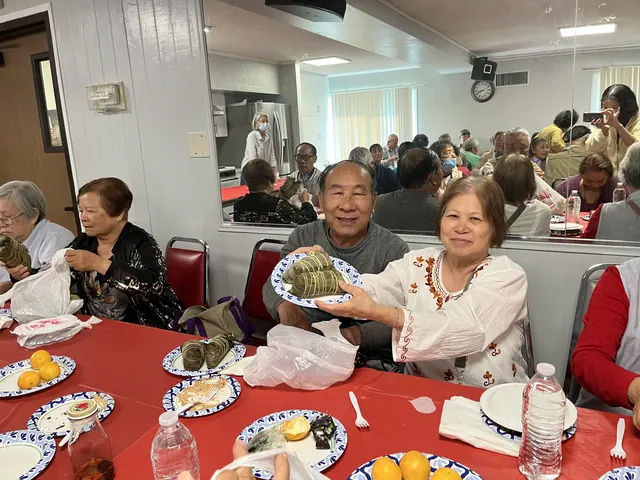 Residents smiling with plates of zongzi
