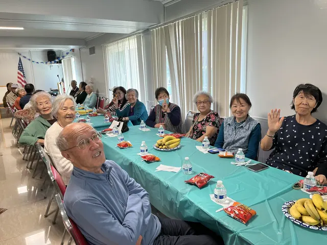 Residents smiling and waving at the birthday gathering
