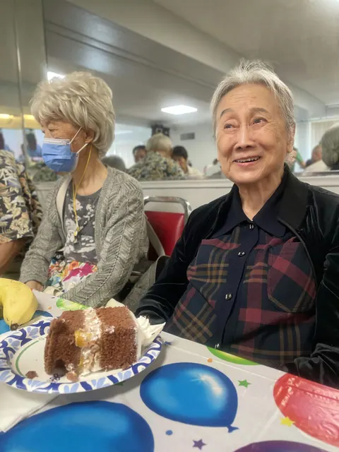 A smiling resident with a slice of birthday cake