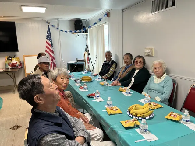 Residents seated at a long table with refreshments