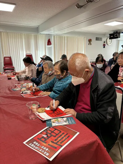 Residents concentrating on writing New Year calligraphy on red paper