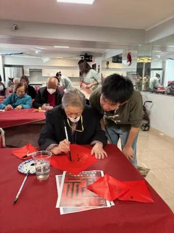 A resident writing a "Fu" character with a calligraphy brush