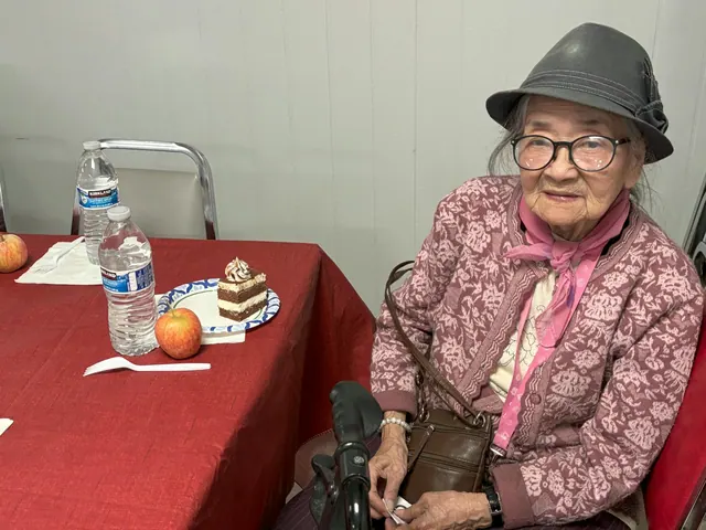 A resident seated at the table with birthday cake and an apple