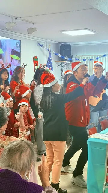 Kam Kwong Church members in Santa hats singing at the birthday party