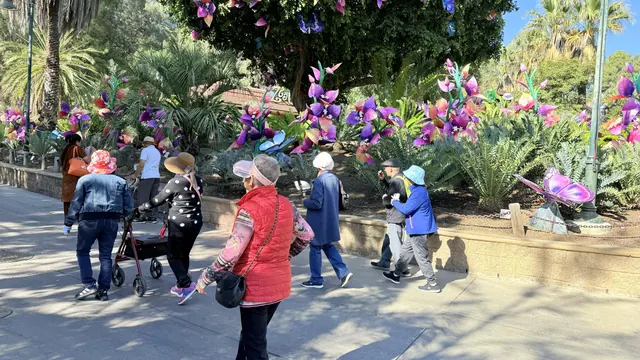 Residents strolling past a garden of flower and butterfly lanterns