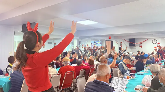 A performer in a reindeer headband leading the room in dance movements