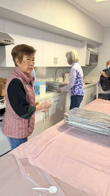 Volunteers preparing food in the kitchen for the birthday party