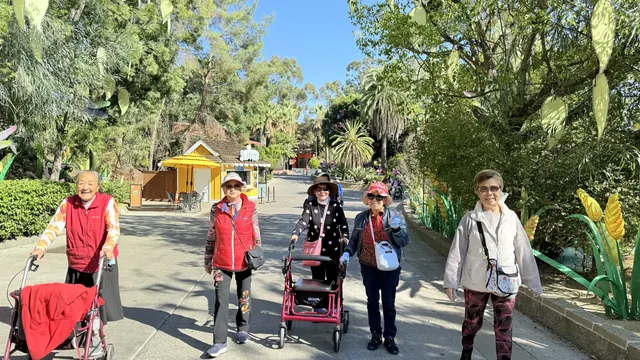 Residents waving on a sunny zoo path