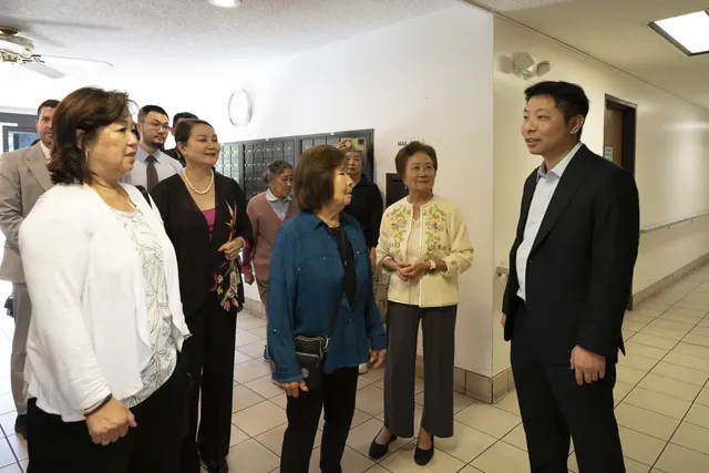 Guests chatting in an interior hallway during the visit