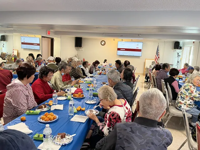 Wide view of the activity hall filled with residents at the May birthday party