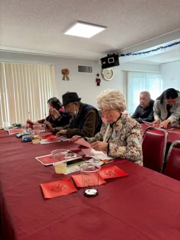 Residents around a long table during the New Year calligraphy activity
